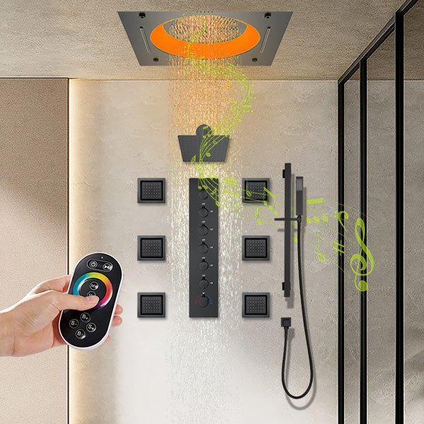 Shower system with multiple outlets and a hand holding a remote control.